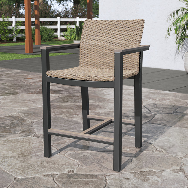 Single brown high bar stool with back and footrest on stone patio