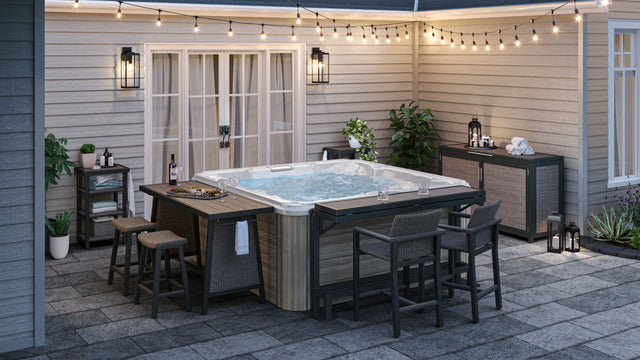 Brown dining table, bar, bar chairs, deck box, and towel valet surrounding outdoor hot tub on patio