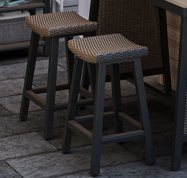 Two brown backless bar stools nestled under at dining table by outdoor hot tub on patio