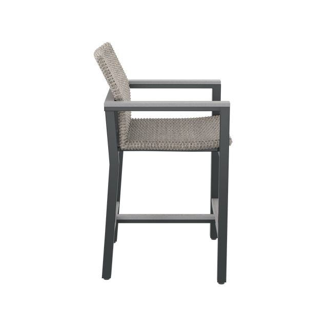 Side of gray high-backed bar chair with armrests and footrest 