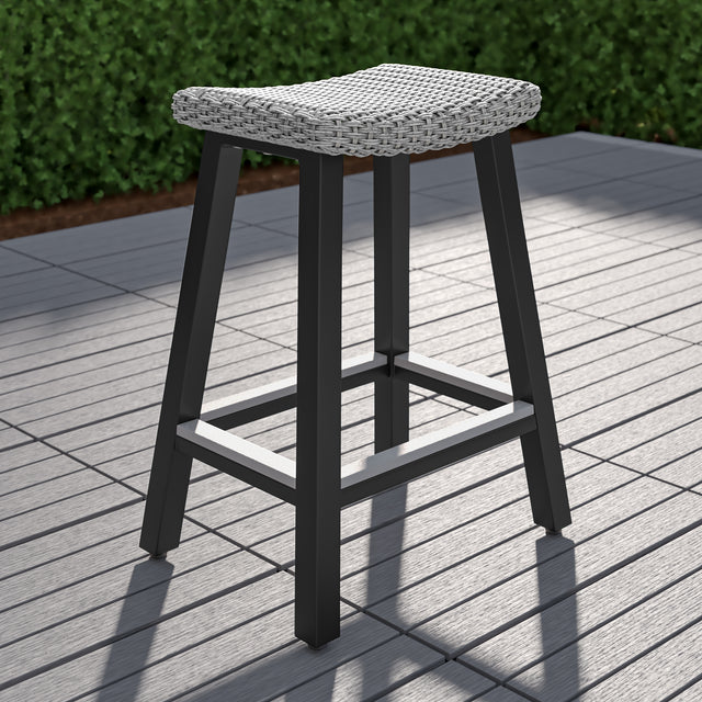 Single gray backless bar stool on outdoor patio 