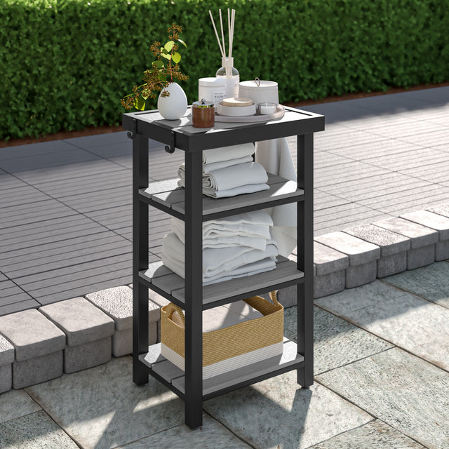 Four-tier gray towel valet with shelving holding towels, plants, and other spa and patio accessories