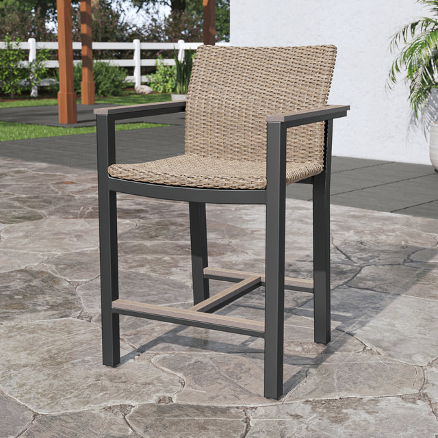 Single brown high bar stool with back and footrest on stone patio 